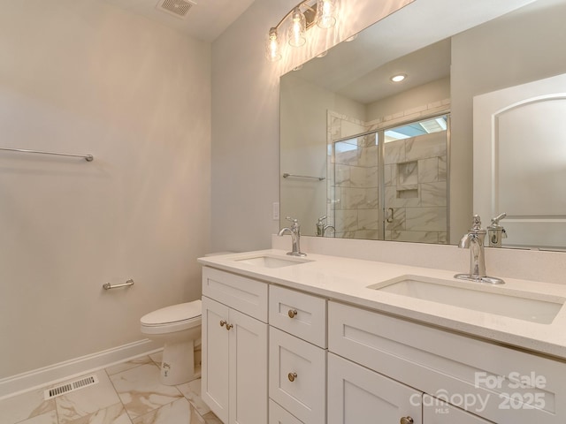 bathroom featuring vanity, toilet, and a shower with shower door