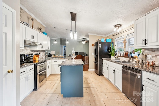 kitchen featuring sink, ceiling fan, appliances with stainless steel finishes, decorative light fixtures, and a kitchen island