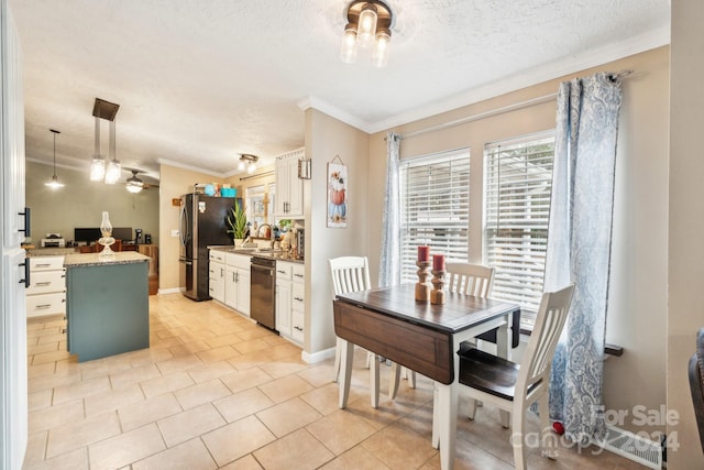 dining area with sink, light tile patterned floors, a textured ceiling, and ornamental molding