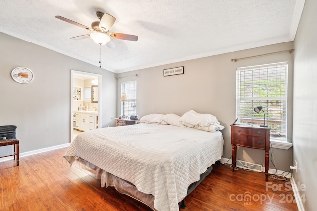 bedroom featuring ensuite bathroom, vaulted ceiling, hardwood / wood-style flooring, ceiling fan, and a textured ceiling