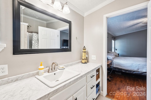 bathroom featuring hardwood / wood-style floors, vanity, ornamental molding, a textured ceiling, and curtained shower