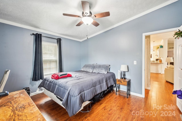 bedroom featuring a textured ceiling, ceiling fan, crown molding, and light hardwood / wood-style flooring