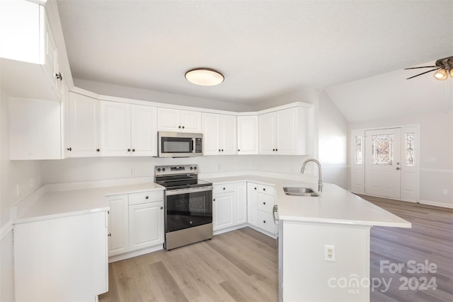 kitchen featuring kitchen peninsula, stainless steel appliances, sink, light hardwood / wood-style flooring, and white cabinetry