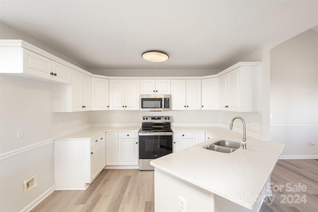 kitchen with white cabinetry, sink, light wood-type flooring, and appliances with stainless steel finishes