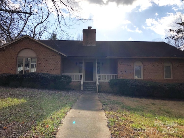 single story home featuring a porch and a front yard