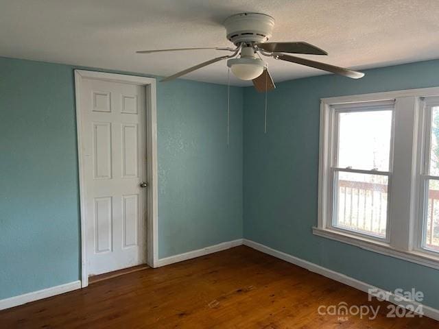 unfurnished room with dark hardwood / wood-style flooring and ceiling fan