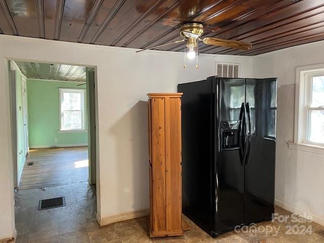 kitchen with wooden ceiling, black fridge, ceiling fan, and a healthy amount of sunlight