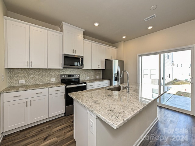 kitchen featuring stainless steel appliances, dark wood-type flooring, sink, white cabinetry, and an island with sink