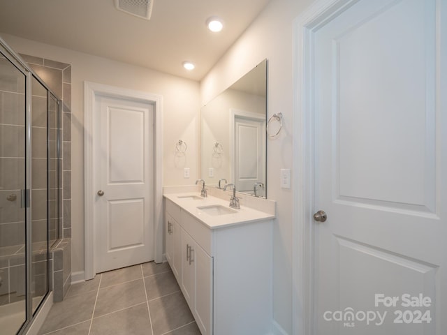 bathroom featuring tile patterned flooring, vanity, and an enclosed shower