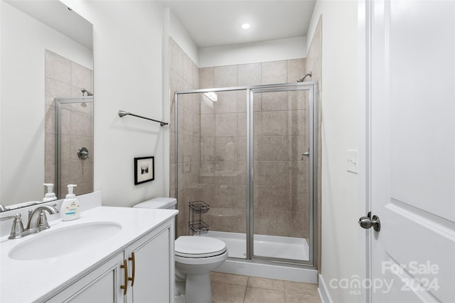 bathroom with tile patterned flooring, vanity, toilet, and an enclosed shower