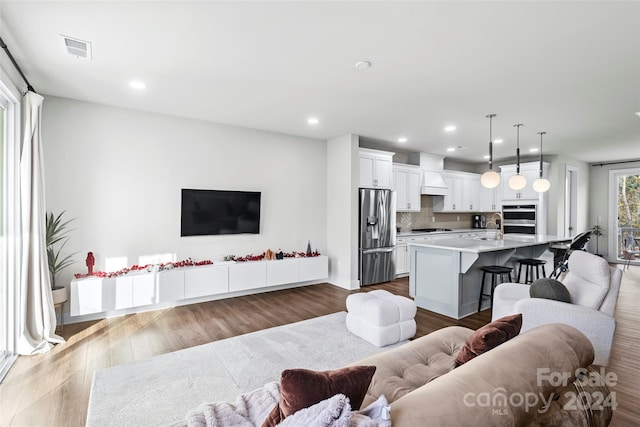 living room featuring sink and light hardwood / wood-style floors