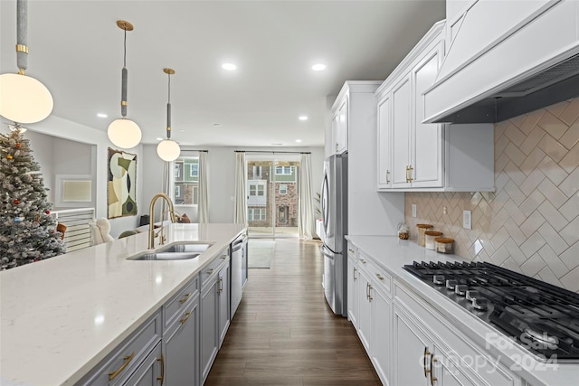 kitchen with sink, stainless steel appliances, hanging light fixtures, decorative backsplash, and custom exhaust hood