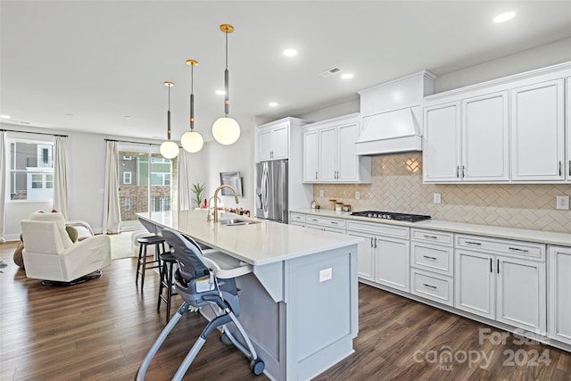 kitchen with sink, pendant lighting, a center island with sink, white cabinets, and appliances with stainless steel finishes