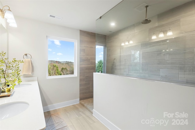 bathroom with vanity, wood-type flooring, and tiled shower