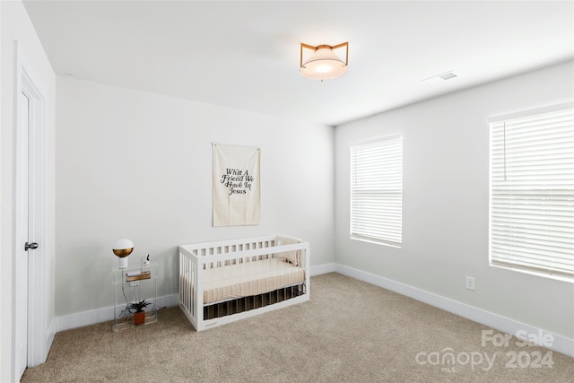 bedroom with carpet flooring and a nursery area