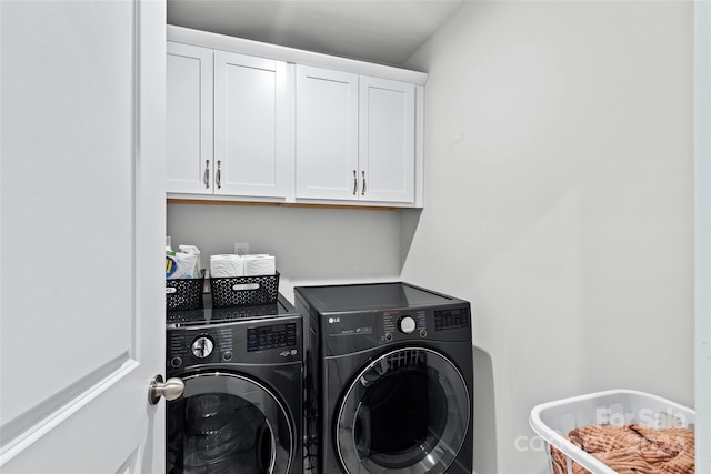 laundry room featuring washer and dryer and cabinets