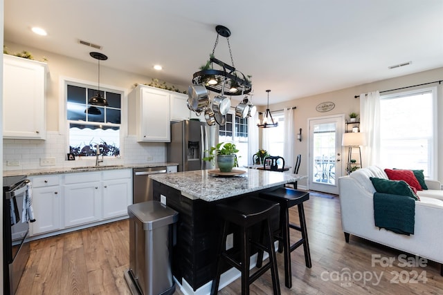 kitchen featuring white cabinets, a center island, and stainless steel appliances