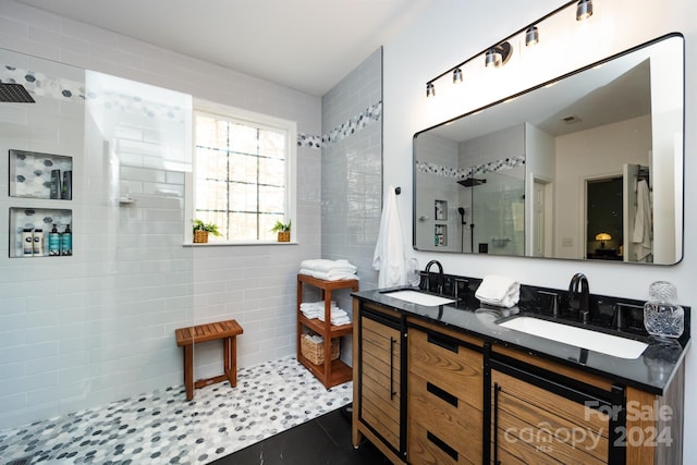 bathroom with tiled shower, vanity, and tile patterned floors