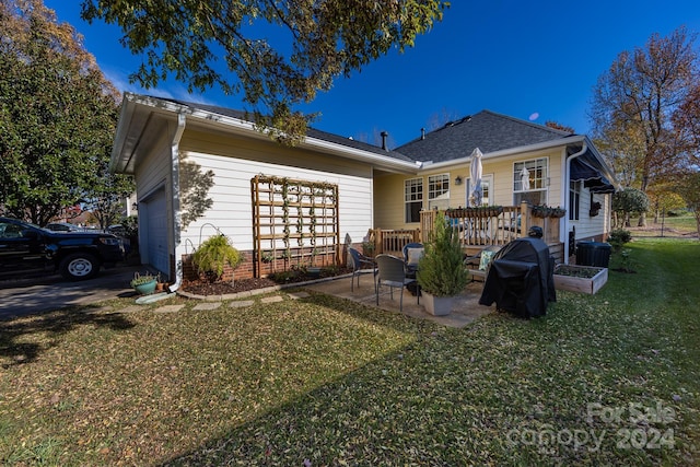 rear view of property featuring a lawn and a garage