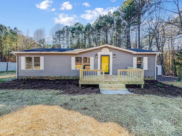 view of front facade featuring a deck and a front lawn