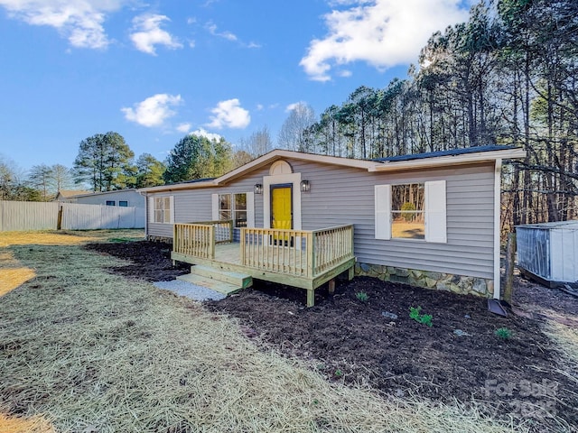 view of front of house with a deck and a front lawn