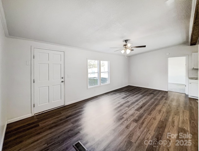 unfurnished living room featuring a textured ceiling, dark hardwood / wood-style floors, ceiling fan, and ornamental molding