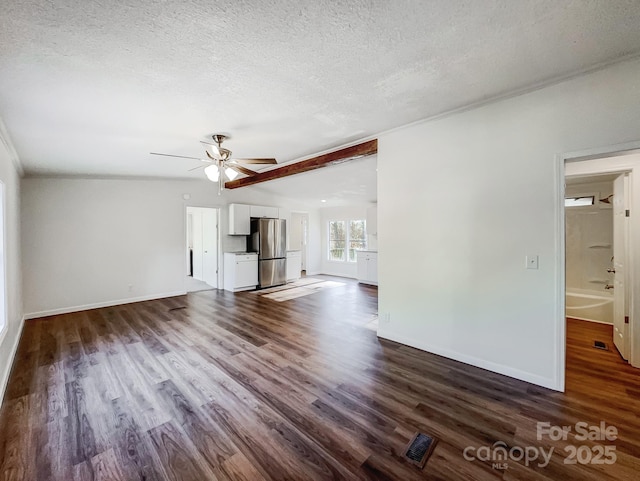 unfurnished living room featuring a textured ceiling, ceiling fan, and dark wood-type flooring