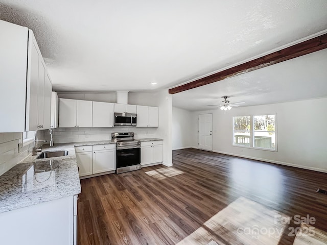 kitchen with sink, decorative backsplash, light stone counters, white cabinetry, and stainless steel appliances