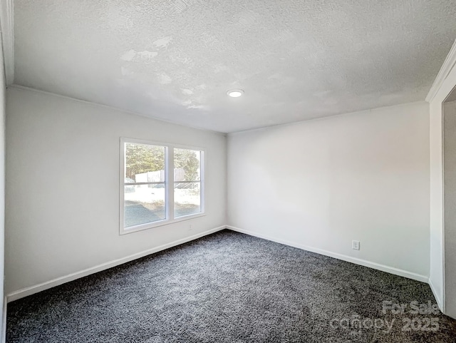 unfurnished room with a textured ceiling and dark colored carpet