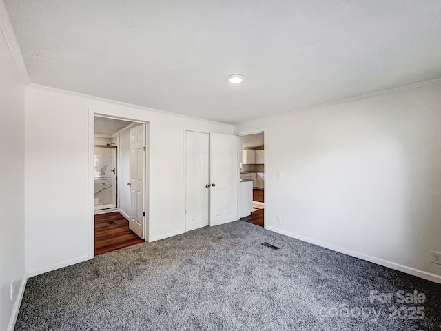 unfurnished bedroom featuring dark carpet and crown molding