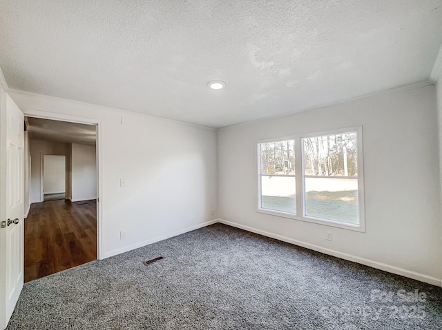 carpeted spare room featuring a textured ceiling