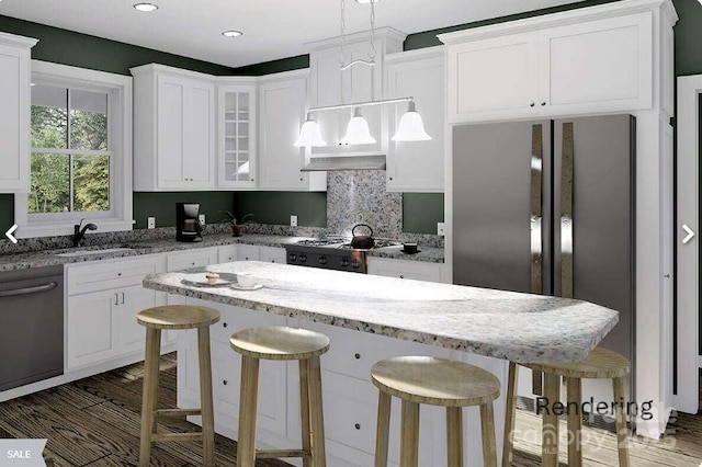 kitchen featuring stainless steel appliances, sink, a breakfast bar area, and hanging light fixtures