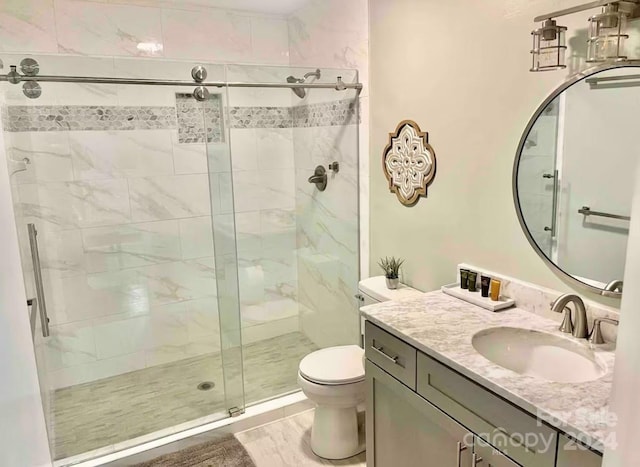 bathroom with toilet, an enclosed shower, and vanity