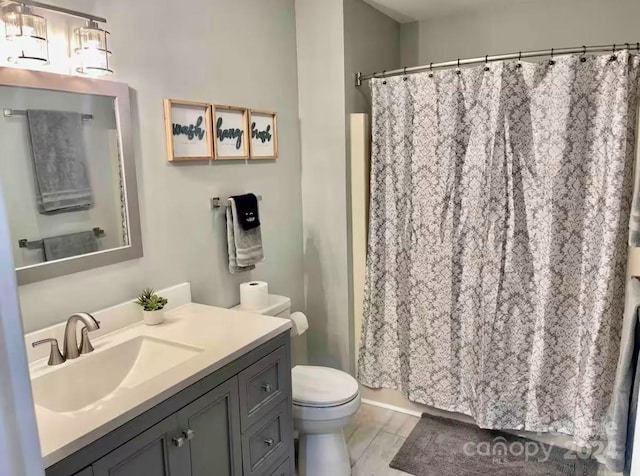 bathroom with vanity, toilet, and curtained shower