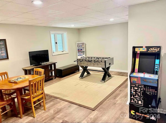 game room with a drop ceiling and hardwood / wood-style floors