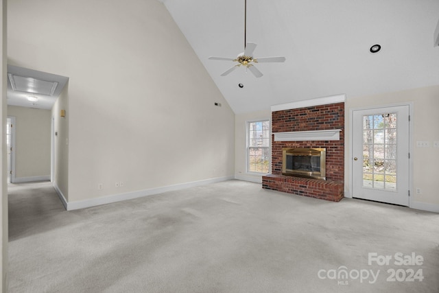 unfurnished living room with ceiling fan, light colored carpet, a fireplace, and high vaulted ceiling