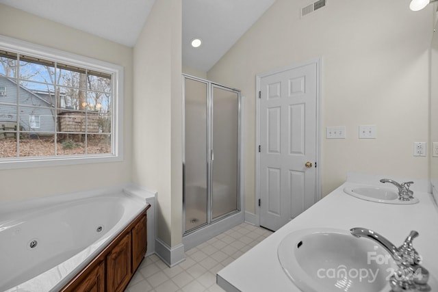 bathroom featuring vanity, independent shower and bath, and vaulted ceiling