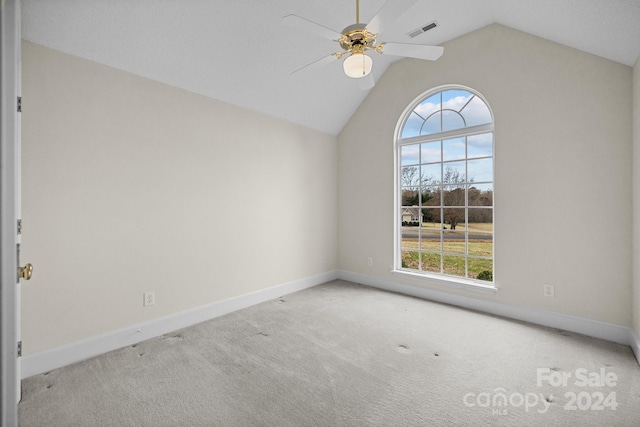 carpeted spare room with vaulted ceiling and ceiling fan