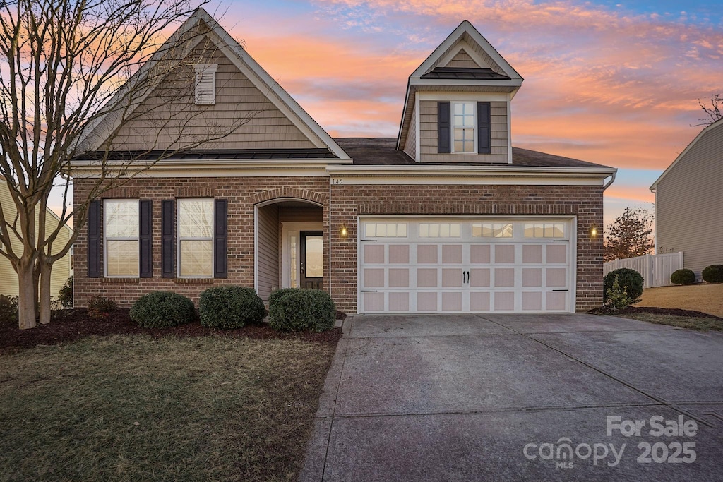 view of front of property with a yard and a garage