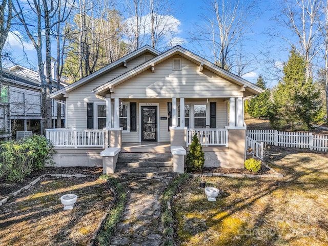 bungalow featuring covered porch and a front lawn