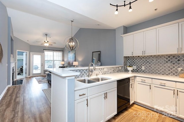 kitchen featuring black dishwasher, sink, white cabinets, hanging light fixtures, and kitchen peninsula