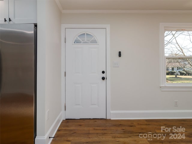 foyer entrance featuring crown molding and dark wood-type flooring