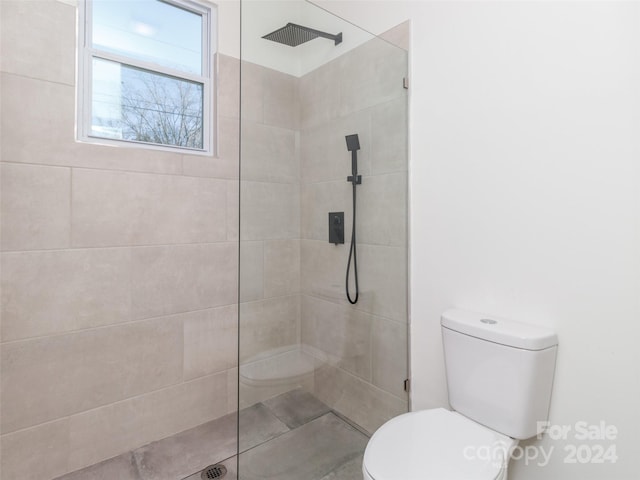 bathroom with tiled shower and toilet