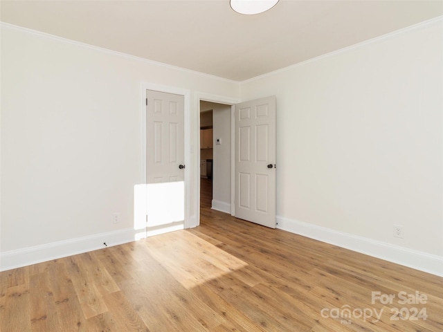 unfurnished room with wood-type flooring and crown molding