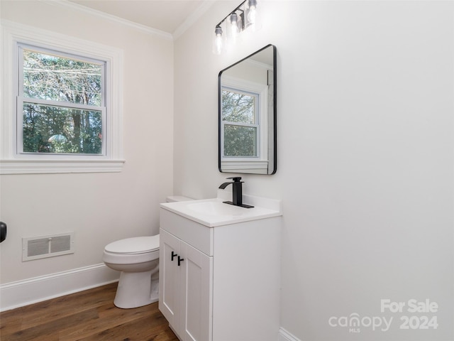 bathroom featuring wood-type flooring, vanity, ornamental molding, and toilet