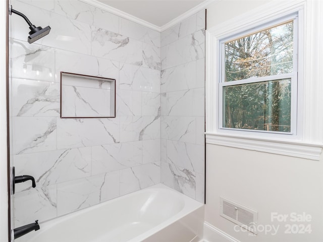 bathroom featuring plenty of natural light, crown molding, and tiled shower / bath