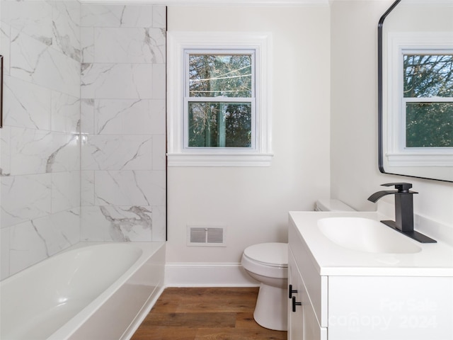 full bathroom featuring vanity, hardwood / wood-style flooring, toilet, and tiled shower / bath