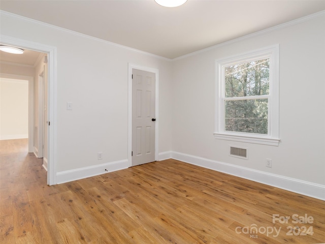 unfurnished room with light hardwood / wood-style flooring and ornamental molding