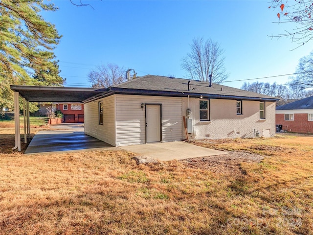 rear view of property featuring a yard, a patio, and a carport