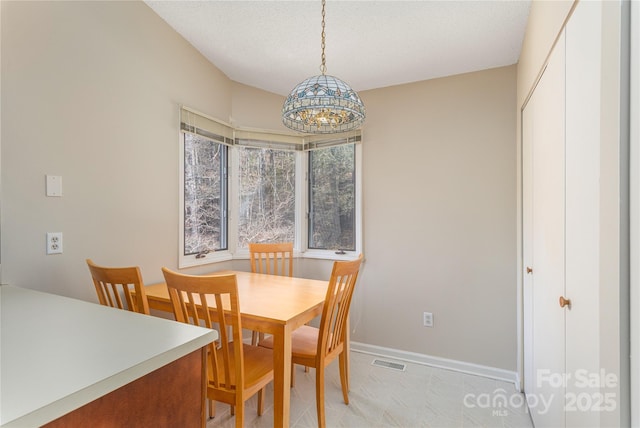 dining room with a textured ceiling and light tile patterned flooring